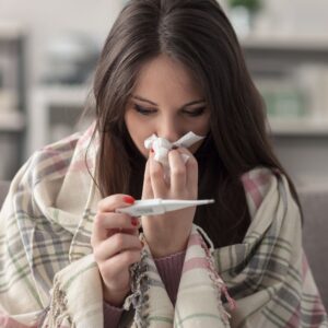 photo of a woman sick with a fever for a blog post about exercise when you are sick by Sport & Spine